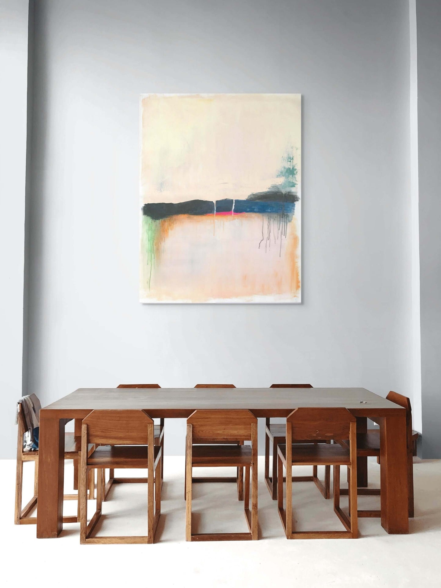 Modern dining room featuring original oil painting 'Where the Sky Remembers' above a wooden dining table.