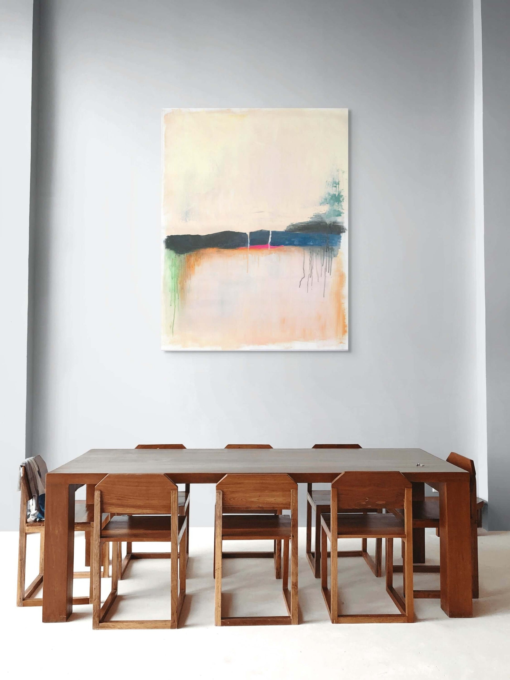 Modern dining room featuring original oil painting 'Where the Sky Remembers' above a wooden dining table.